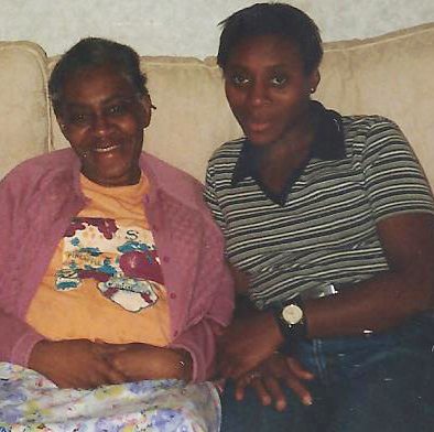 mum and daughter smiling and sitting on a sofa