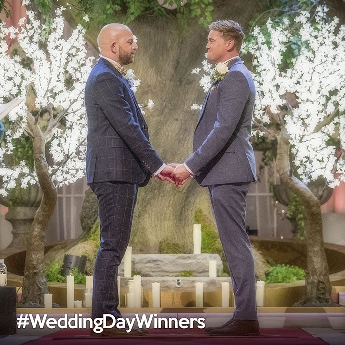 two men holding hands at the wedding altar