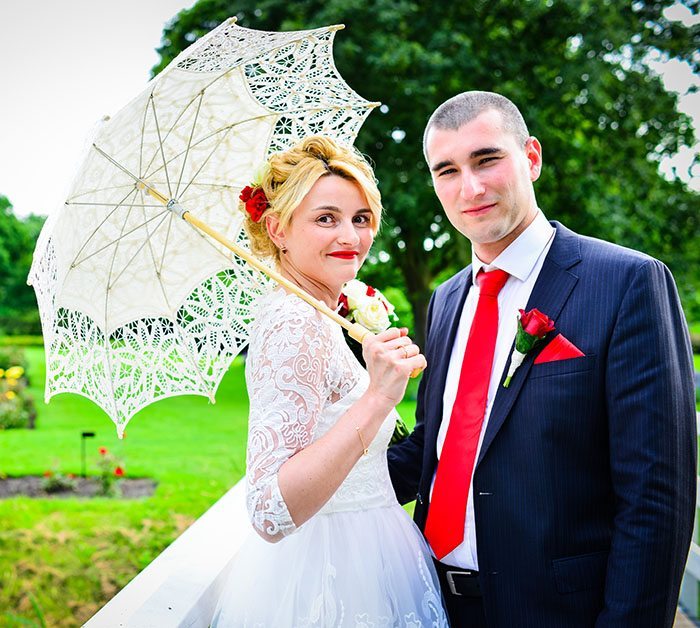 vondelpark wedding bride holding white lace umbrella and posing with the groom