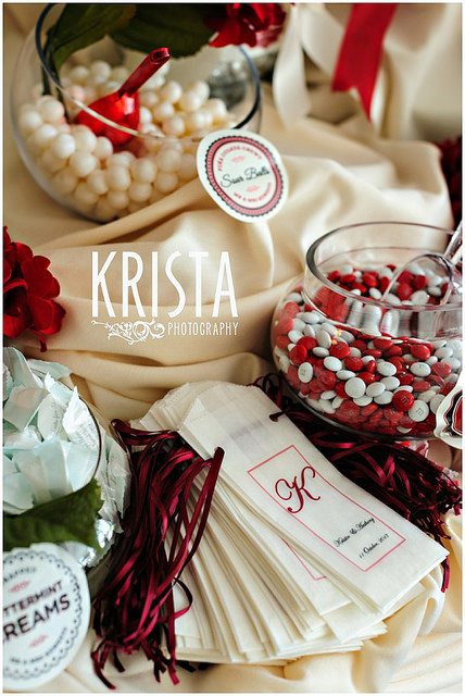 bowls of sweets and wedding thank you gifts on a cream satin dressed satin table