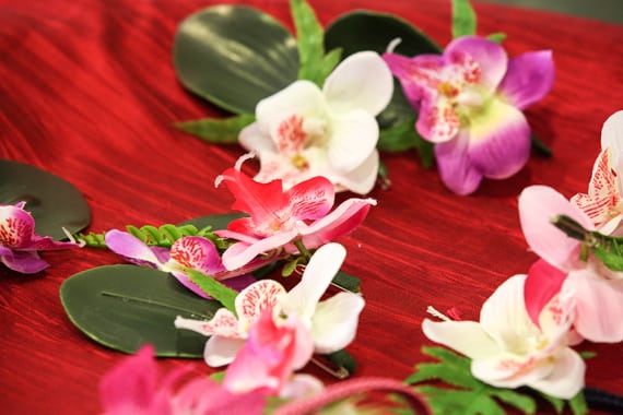 Green, pink and white exotic flowers with green foliage used for brides and grooms’ buttonholes on wedding day