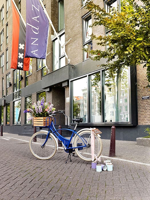 midweek weddings Dutch blue bicycle with tin cans and multicoloured flowers in a wooden basket parked on the prinsengracht Amsterdam