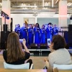 Passende uitvaartmuziek koor gekleed in paarse toga met gouden rand zingen voor het publiek