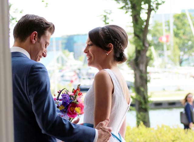 waterside wedding groom embracing bride