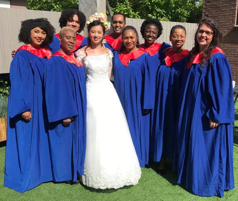 donkere zangeressen gekleed met gewaagd koningsblaauw gospel toga en rode kraag