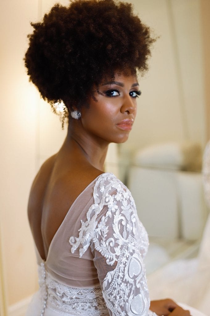 woman with curly hair wearing a laced white bridal gown
