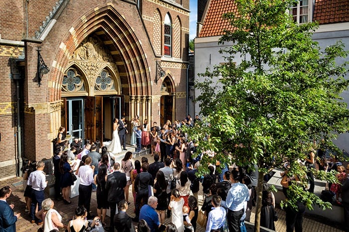 Dutch church wedding venues newlyweds standing on church steps and guests looking on
