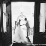 wedding planning scams bride and hotelier walking hand in hand down the stairs to aisle