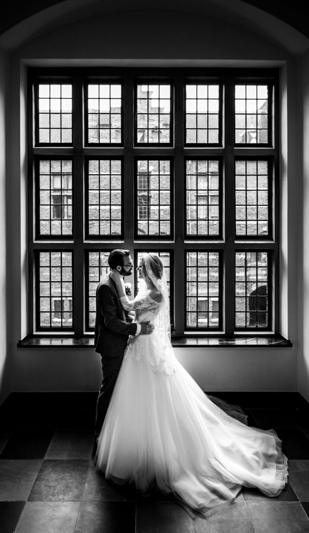 planning couple pose in front of window
