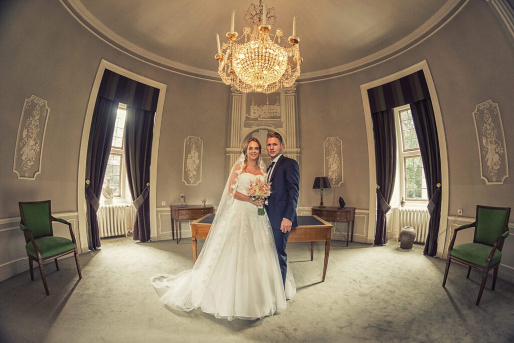 echtpaar poseert onder kristal kroonluchter