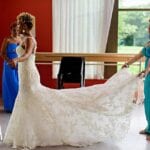 Natural Afro wedding hairstyles bride with maid of honour tending to bridal dress