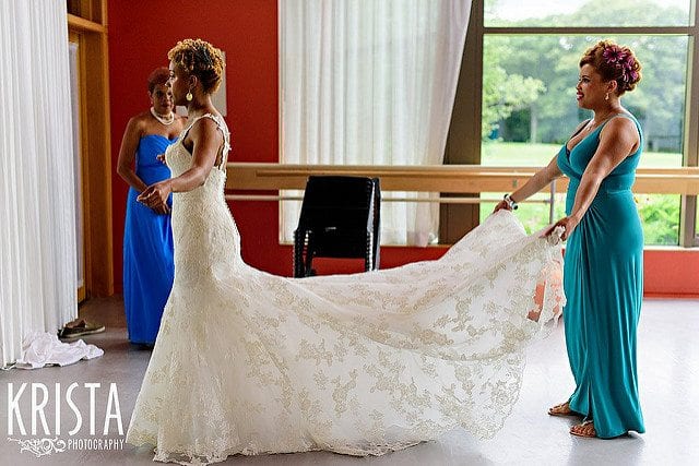 bride with maid of honour tending to bridal dress