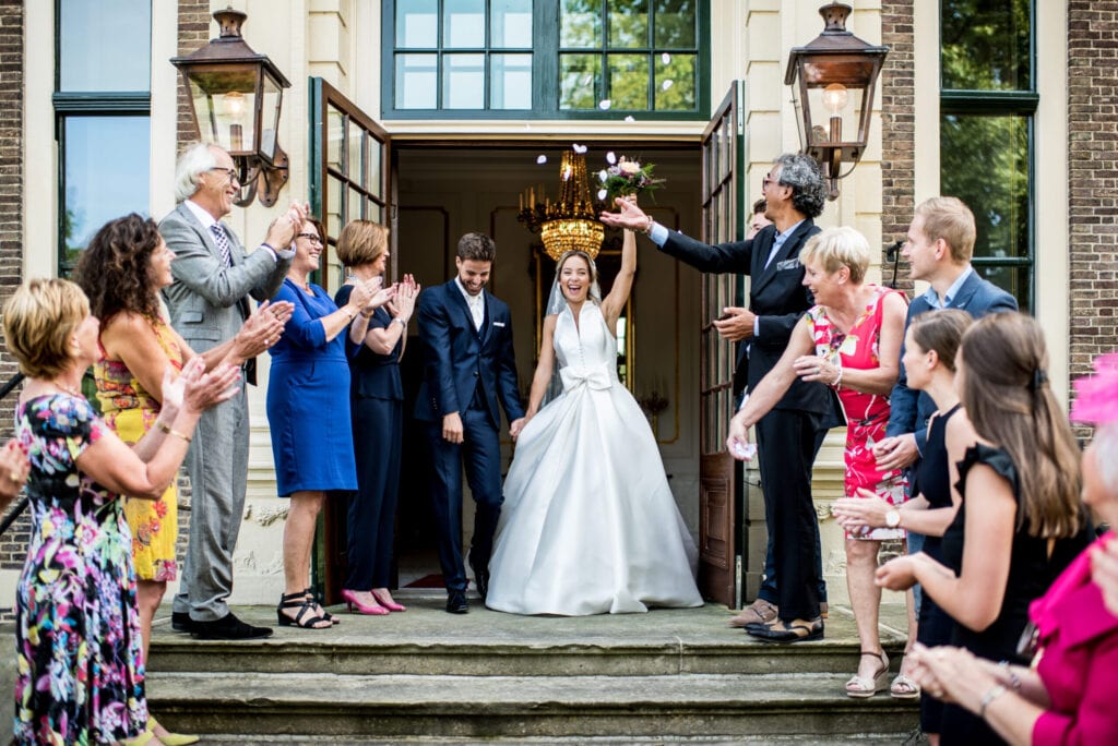 bride and groom holding hands on the steps of castle Ruurlo in Holland