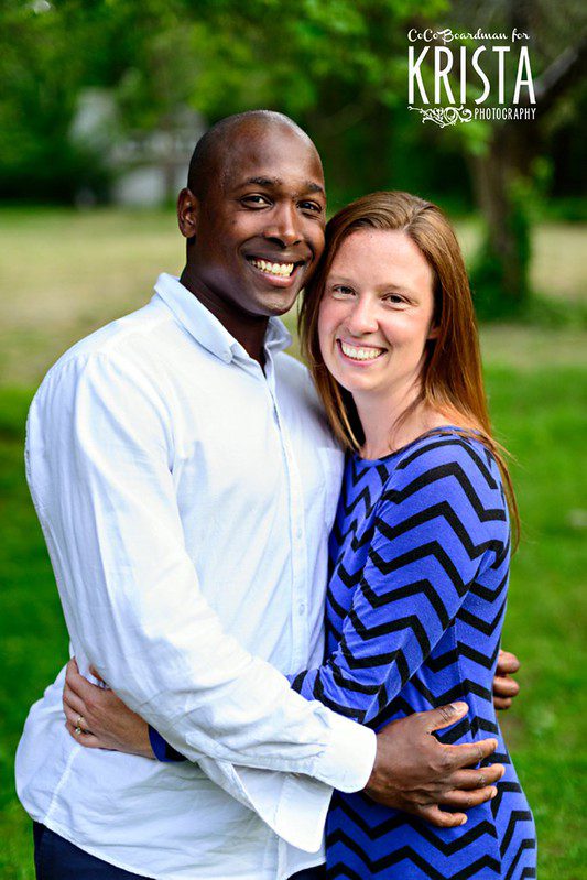 Wedding Ceremony Readings mixed-race couple black african man sitting in the grass with white caucasian woman smiling at one another