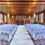 Dutch wedding planners wedding ceremony seating arrangement chairs draped in white linen and aisle floor runner