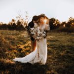 Dutch wedding guide couple holding hands and smiling at lady registrar