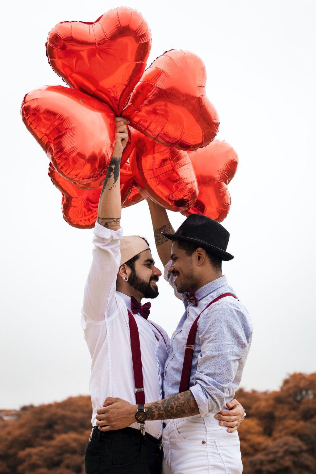 pre-wedding interview questions two men embracing while holding heart balloons-1756632/