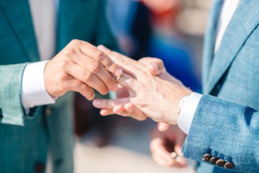same-sex couple holding hands while exchanging rings at the Hanger, Amsterdam