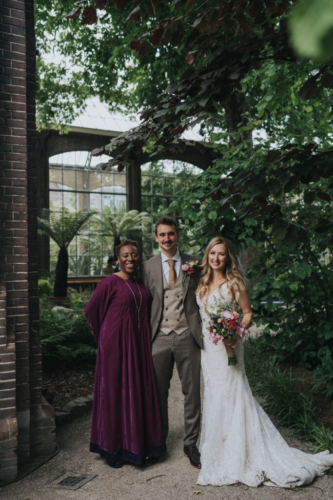 Ervaren trouwambtenaar in een oasis van rust met het bruidspaar tijdens een Avondceremonie, s'avonds bruiloft met zonsondergang bij Hortus Botanicus Amsterdam.
