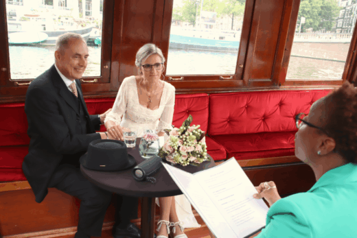 Charming canal boat trip in Amsterdam with a bride and groom renewing their vows during an officiant led ceremony.