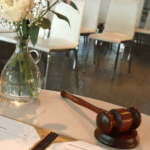 Corona maatregelen voor bruiloften trouwakte met gavel, pen en een witte bloemtje