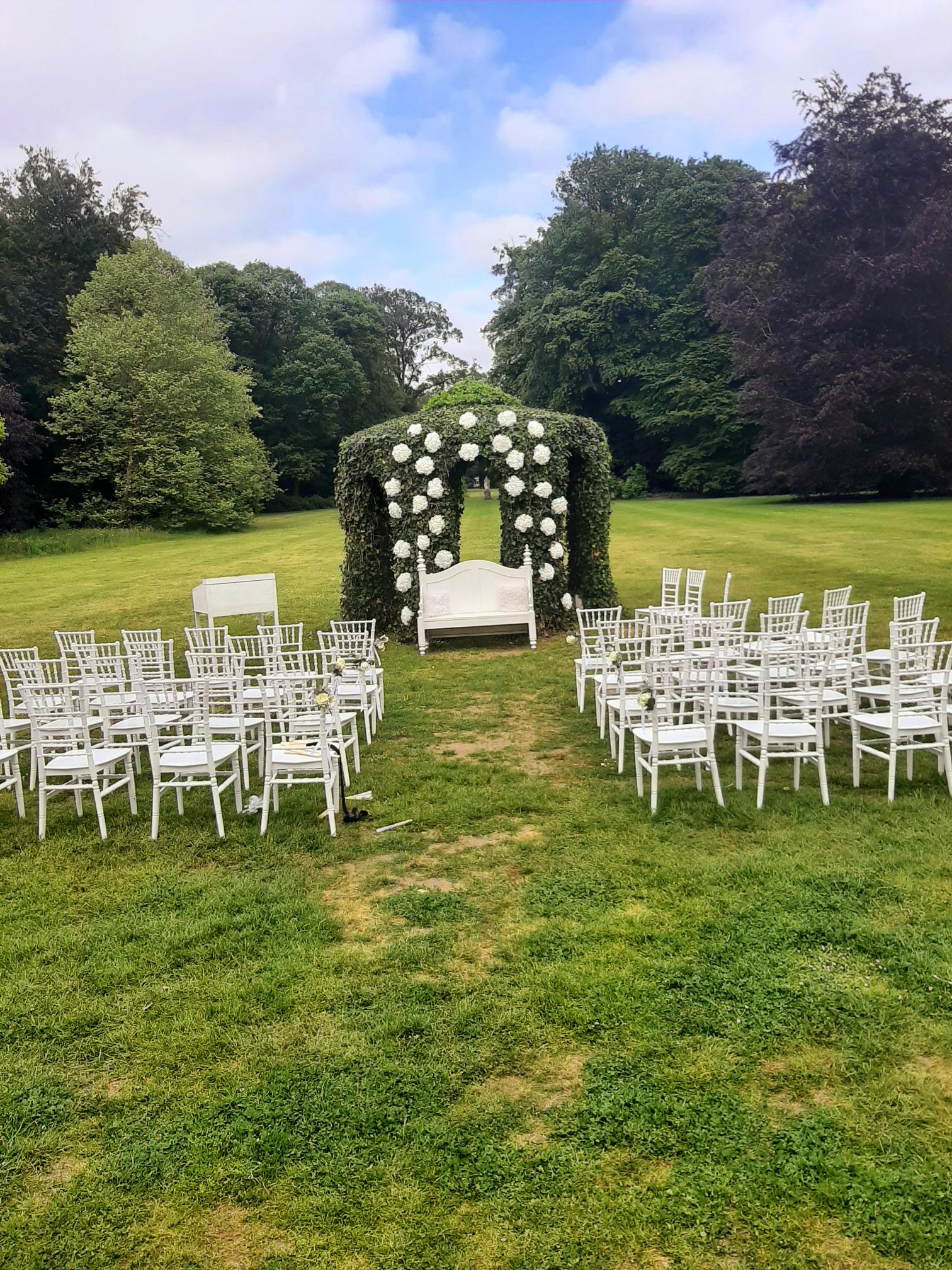 Ceremonial rituals with wedding seating and white floral arch