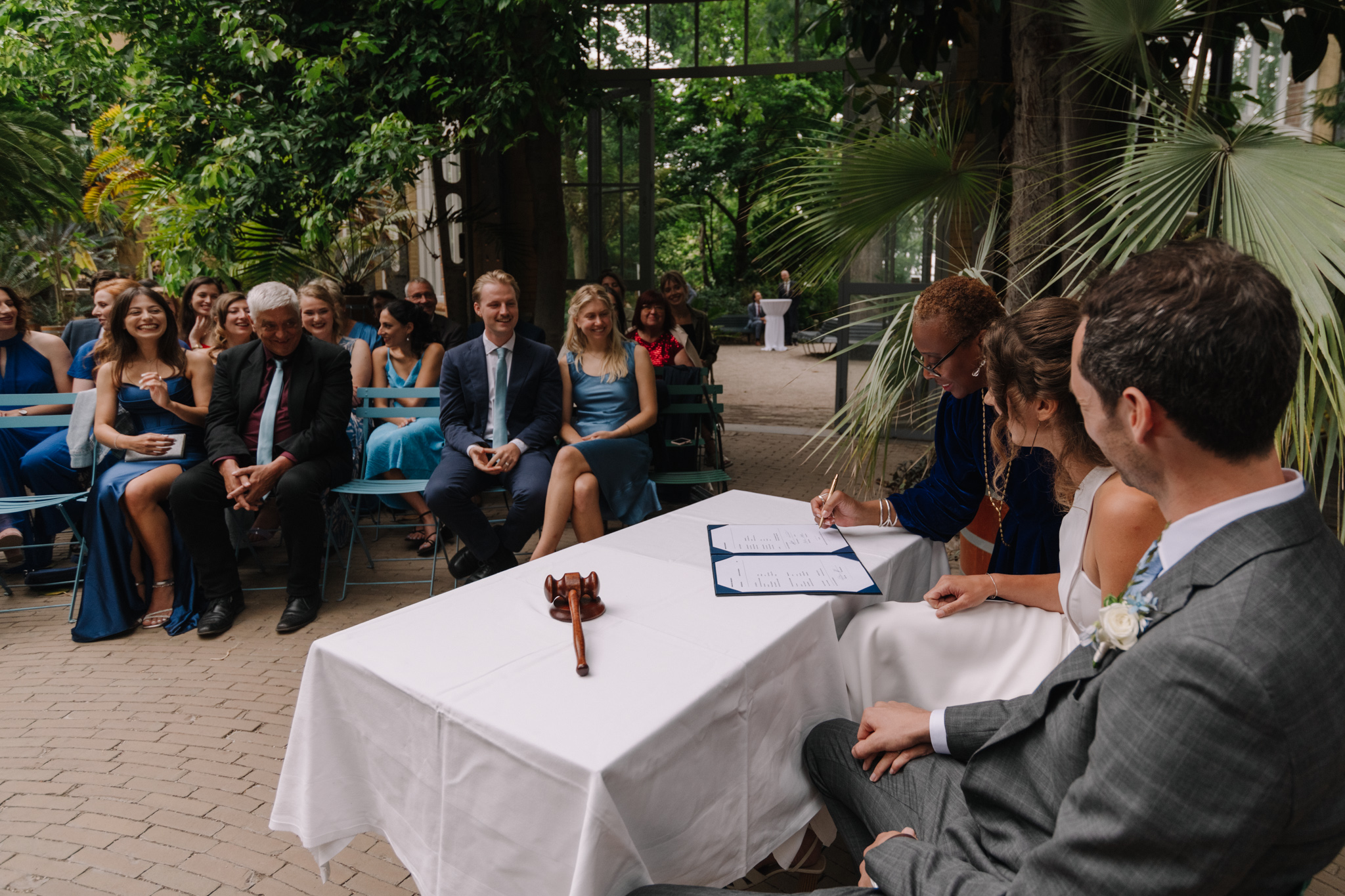 Bride and groom signing a certificate at Hortus Botanicus Amsterdam the perfect setting for a Dutch wedding, legal marriage, secular ceremony and evening wedding celebration.