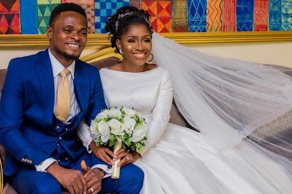 wedding ritual bride holding a white bouquet and holding the groom, both smiling.