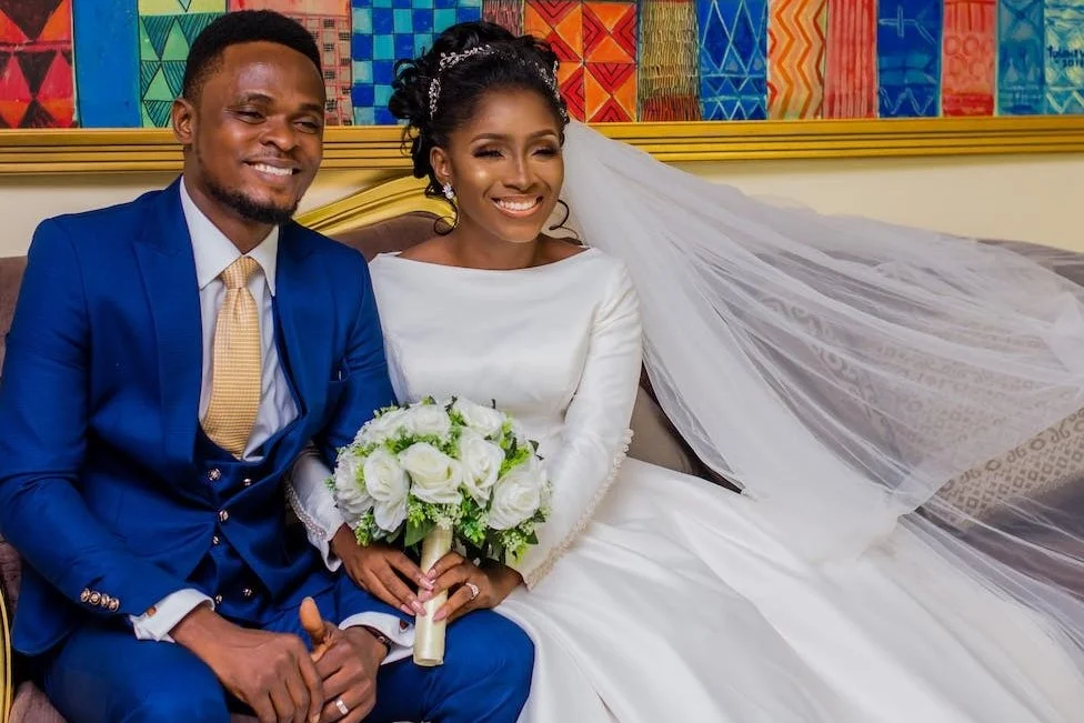 wedding ritual bride holding a white bouquet and holding the groom, both smiling.