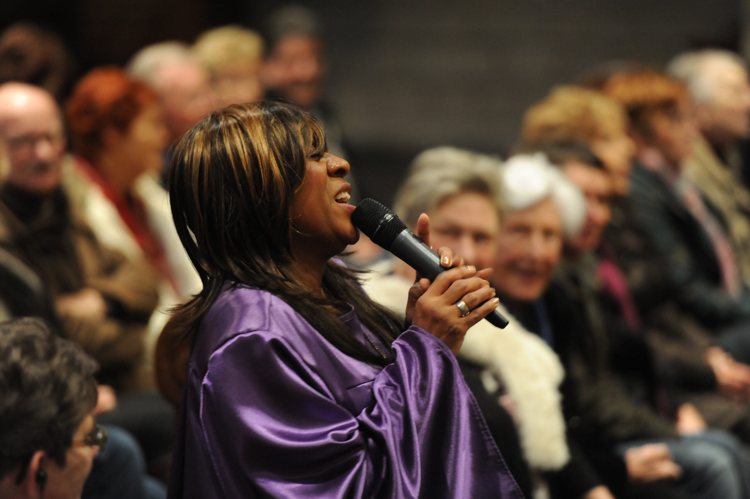 zangeres zingt de allermooiste christelijke liederen voor een publiek in een paarse jurk in Maastricht.