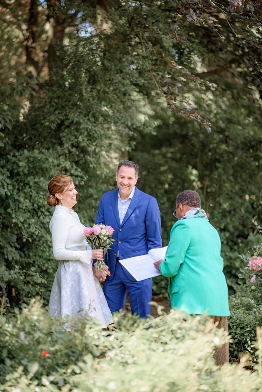 An exclusive destination wedding in the park, featuring an anniversary couple and an officiant.