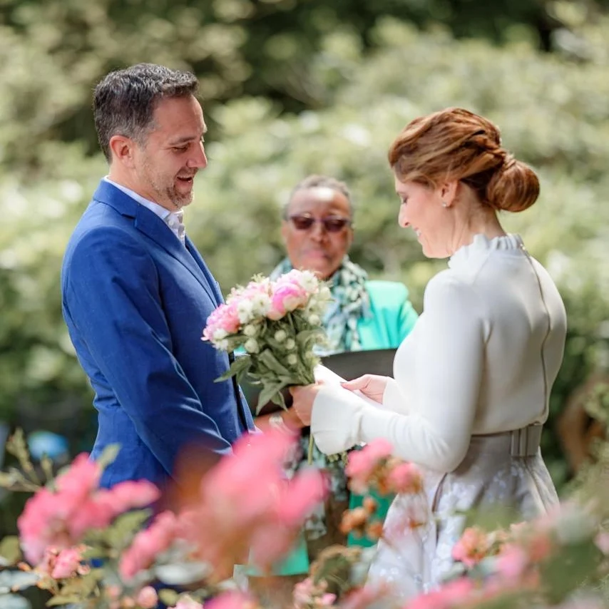 commitment ceremony script - ceremony builder. A bright and cheerful couple getting married by an officiant in a garden.