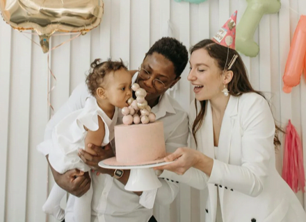 Baby naming ceremony guide for blended family event mother and father holding birthday cake,