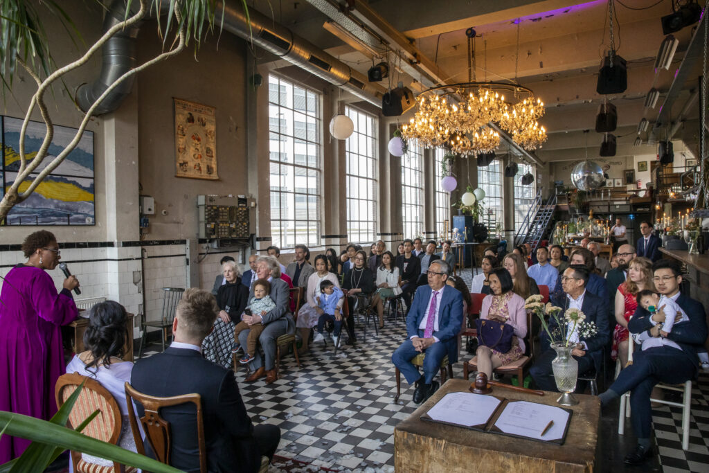Black tie Wedding dress code officiant delivering speech to international guests at Ketelhuis, Eindhoven.