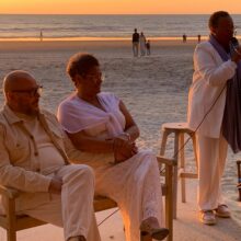 Reviews female Black celebrant marrying a mixed-faith wedding couple as they speak golden-hour vows at the beach in zandvoort, the Netherlands