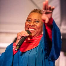 gospel huwelijksceremonie met zangeres gekleed in rood en blauw toga 