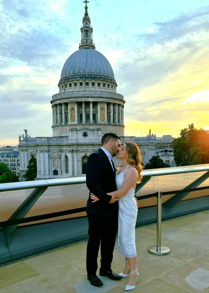 A woman and a man stand holding one another during a ceremony in London, near St. Paul's Cathedral.