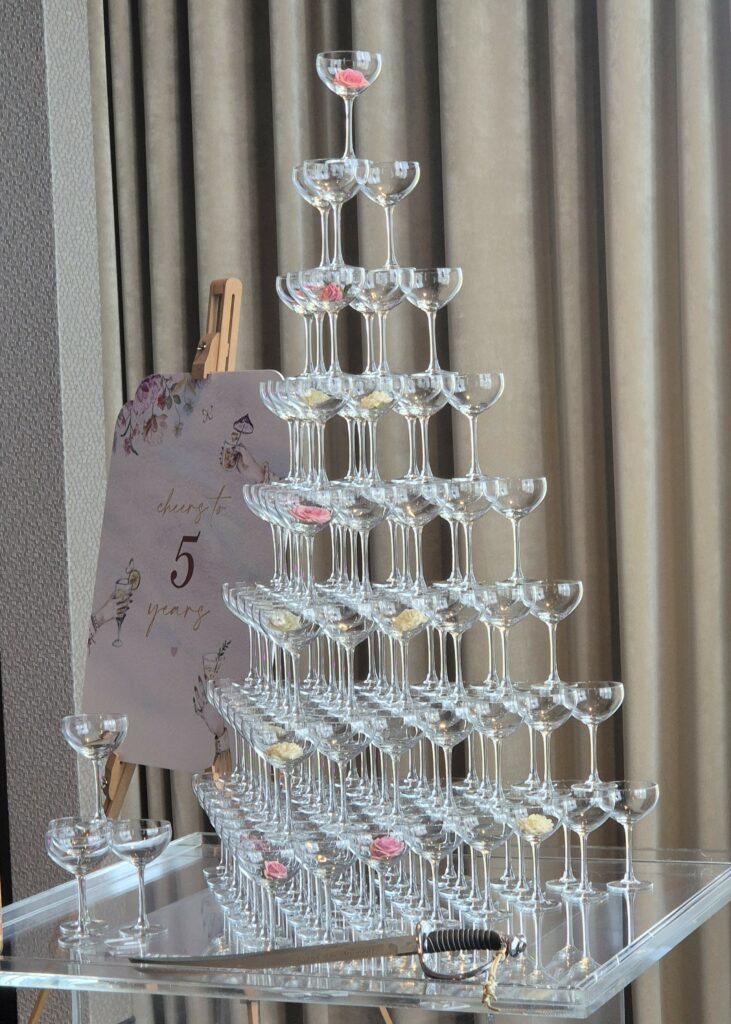 A wedding ritual champagne tower with glasses and a sabre for opening the bottle.