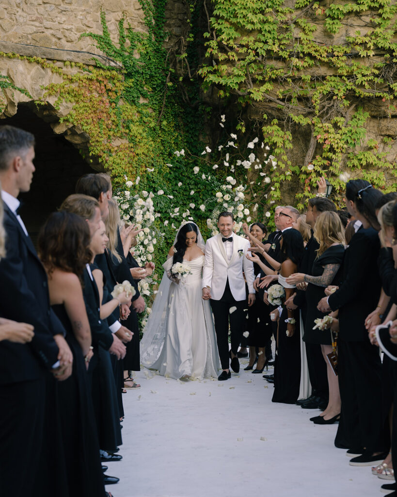 Black bilingual female wedding officiant with bride and groom at Mediterranean wedding venue La Baronia, Barcelona, Spain.
