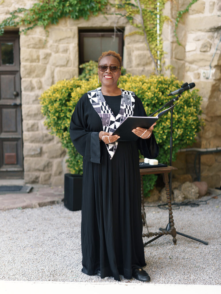 Fusion wedding ceremony officiant smiling and delivering speech in LaBaronia, Barcelona, Spain.