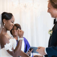 celebrant / officiant wedding ceremony couple smiling and celebrant holding presentation book